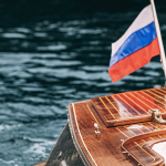 Катер Mia с флагом на воде, прогулка по каналам Санкт-Петербурга аренда катера